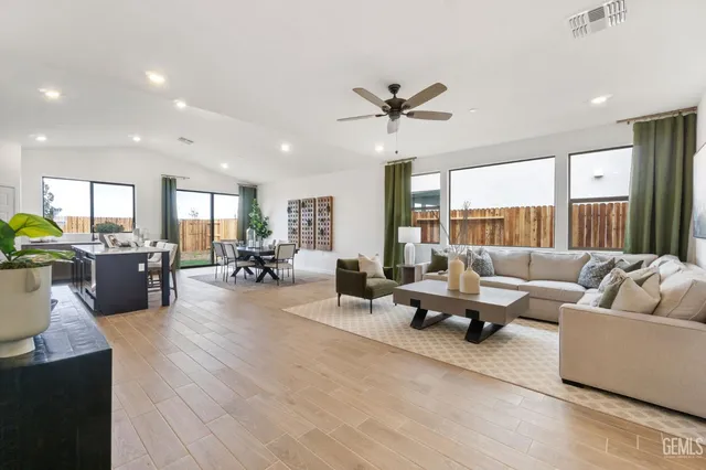 a living room with furniture wooden floor and a large window