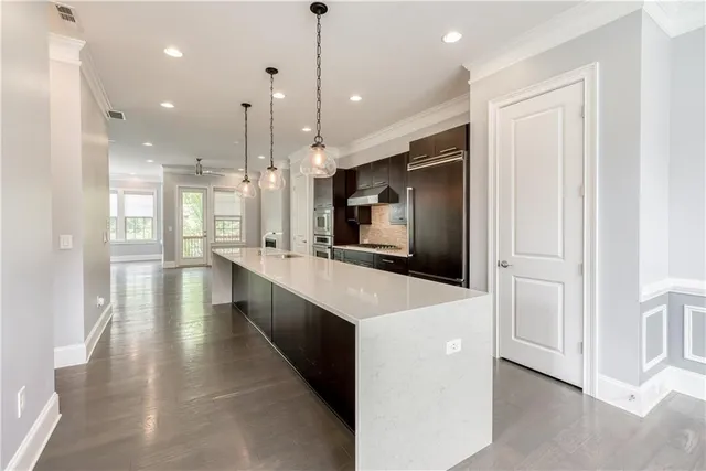 a large kitchen with a large counter top and stainless steel appliances