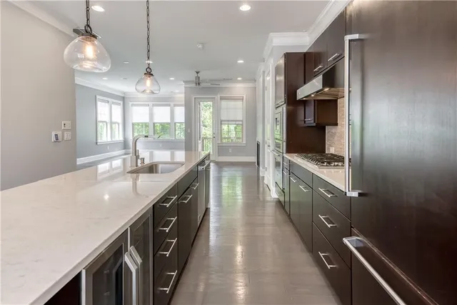 a kitchen with stainless steel appliances granite countertop a sink a stove and a wooden floors