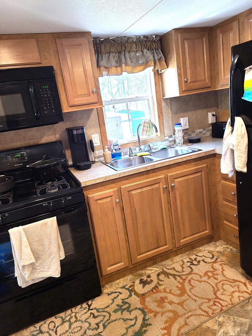 21-80 Woodhaven Sublette, IL 61367 - Photo 15 of 21 a kitchen with granite countertop a stove a sink and a microwave