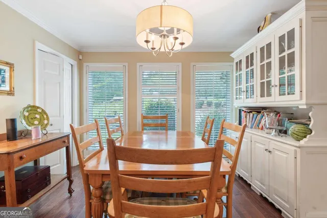 a view of a dining room with furniture a chandelier and wooden floor