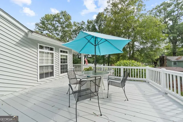 a view of house with wooden deck and furniture