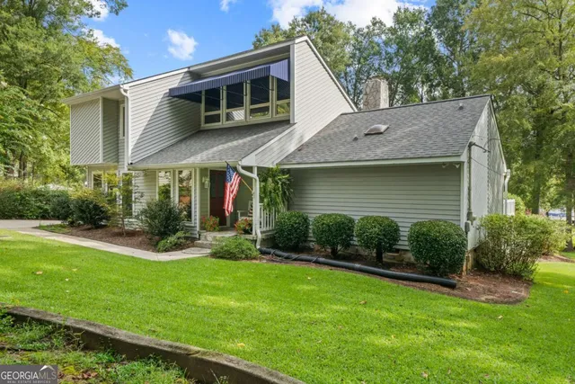 a view of a house with a yard and potted plants
