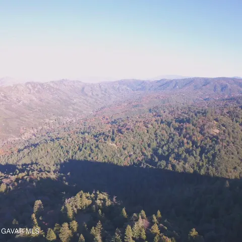 an aerial view of mountain with yard and mountain view in back