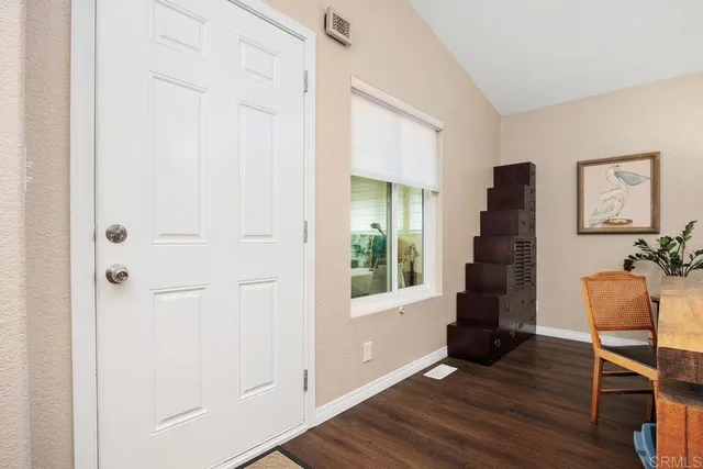 a kitchen with stainless steel appliances kitchen island granite countertop dining table chairs and a large window