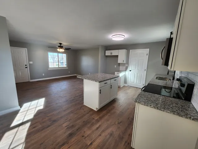 a kitchen with stainless steel appliances granite countertop a sink stove and wooden floor
