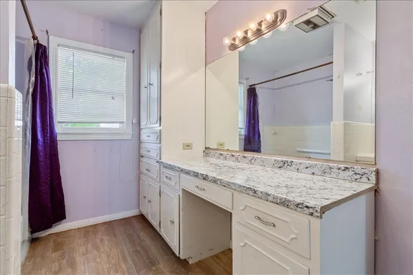 a bathroom with a granite countertop sink and a mirror