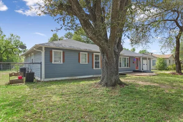 a front view of house with yard and trees