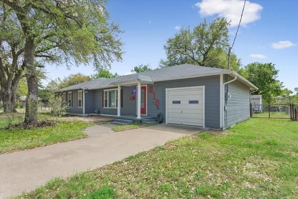 a front view of a house with a garden and yard