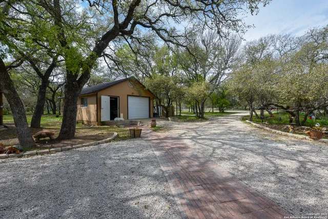 a view of house with backyard and trees