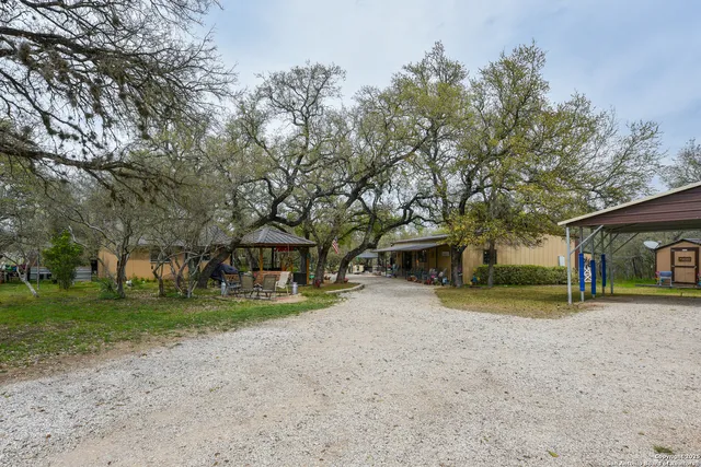 a view of a house with a yard and large trees