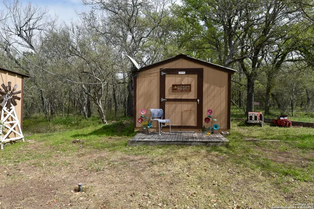 a view of a house with a yard and large tree
