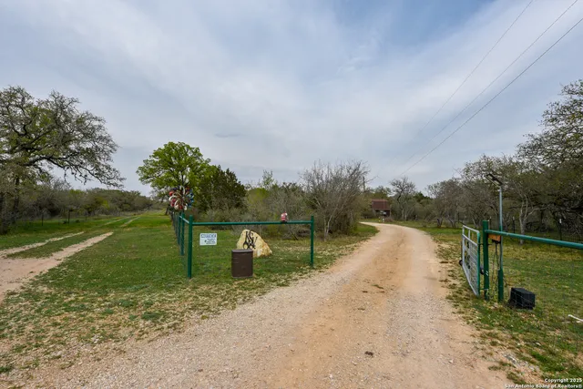 a view of a lake with a big yard and large trees