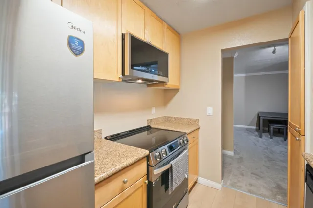 a kitchen with stainless steel appliances granite countertop a stove and a microwave