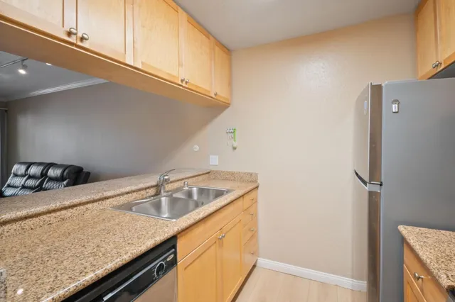 a kitchen with a sink a refrigerator and cabinets