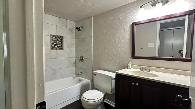 a bathroom with a sink a toilet a mirror a bathtub and shower