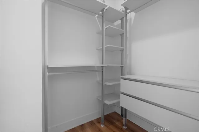 a view of walk in closet with empty racks