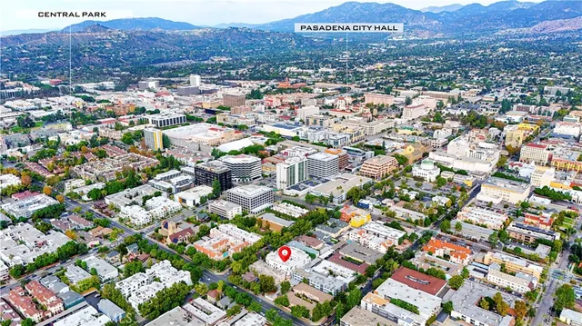 an aerial view of residential houses with outdoor space and trees
