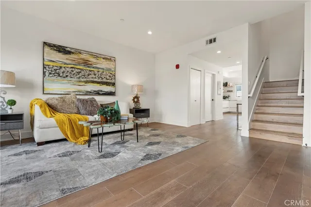 a living room with furniture cabinets and a potted plant