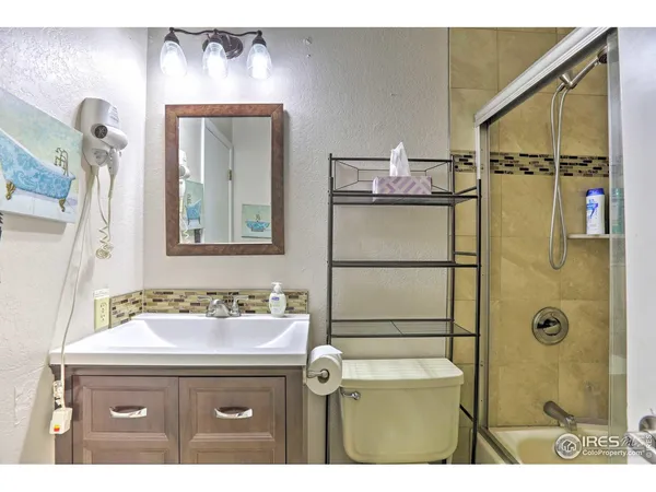 a bathroom with a sink mirror vanity and shower
