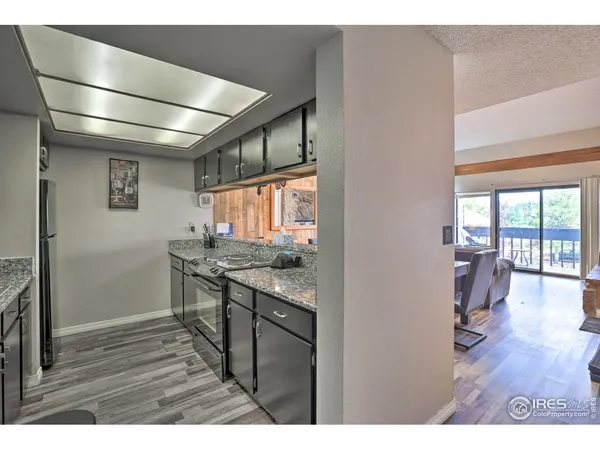a open kitchen with granite countertop a stove and a wooden floors