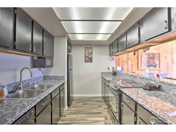 a kitchen with granite countertop a sink and a wooden floor