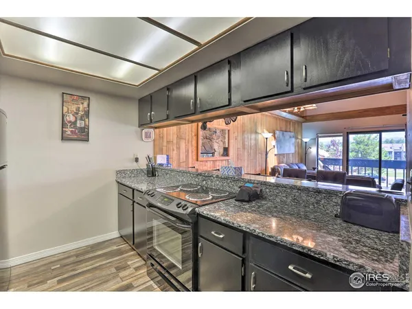 a kitchen with stainless steel appliances granite countertop a sink window and cabinets