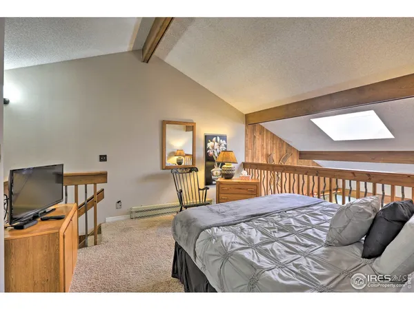 a bedroom with a bed window and a flat screen tv