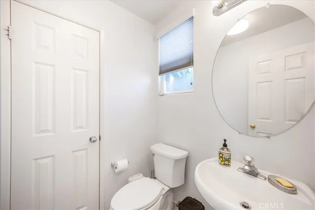 a bathroom with a toilet a sink and a mirror