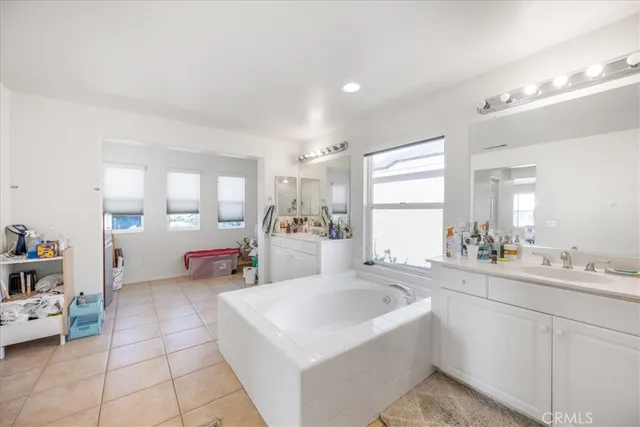 a large white kitchen with a window and a sink