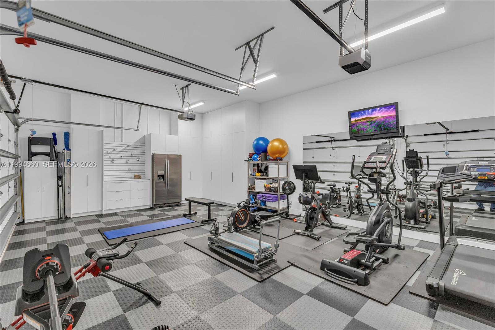 16631 Sunset Way Weston, FL 33326 - Photo 21 of 59 a living room with lots of gym equipment