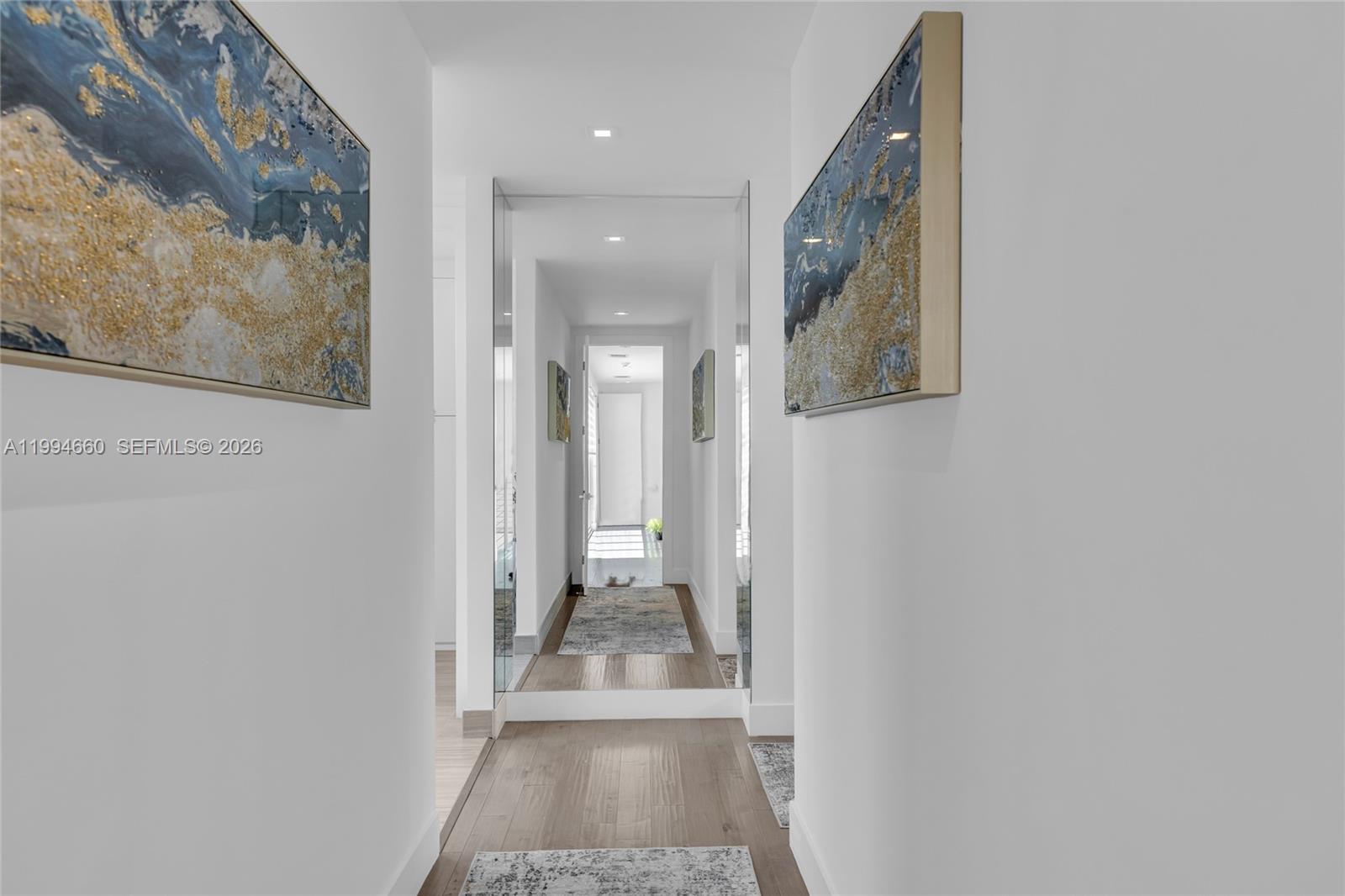 16631 Sunset Way Weston, FL 33326 - Photo 36 of 59 a view of a hallway with wooden floor and a bathroom