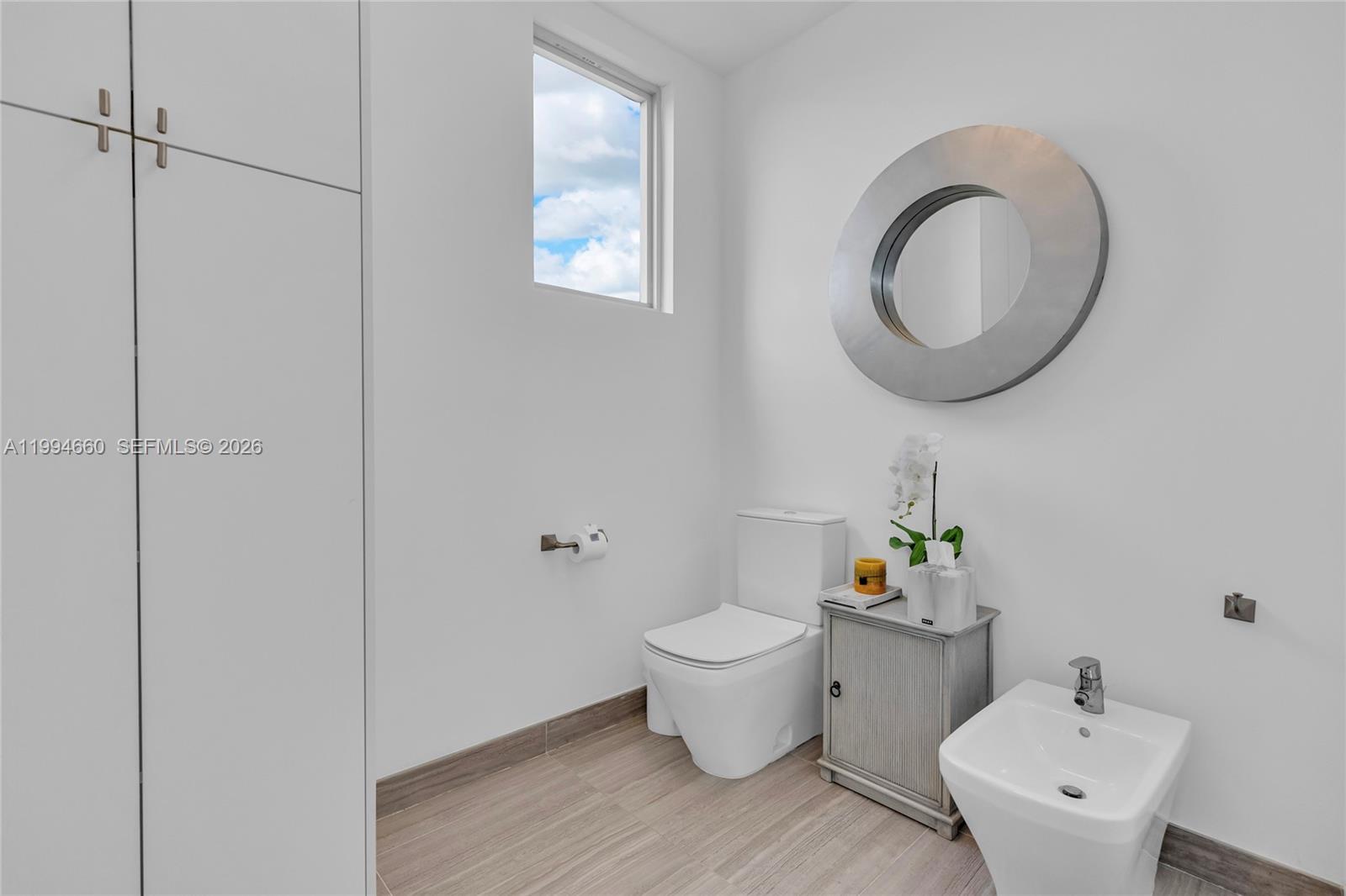 16631 Sunset Way Weston, FL 33326 - Photo 40 of 59 a bathroom with a toilet sink and mirror