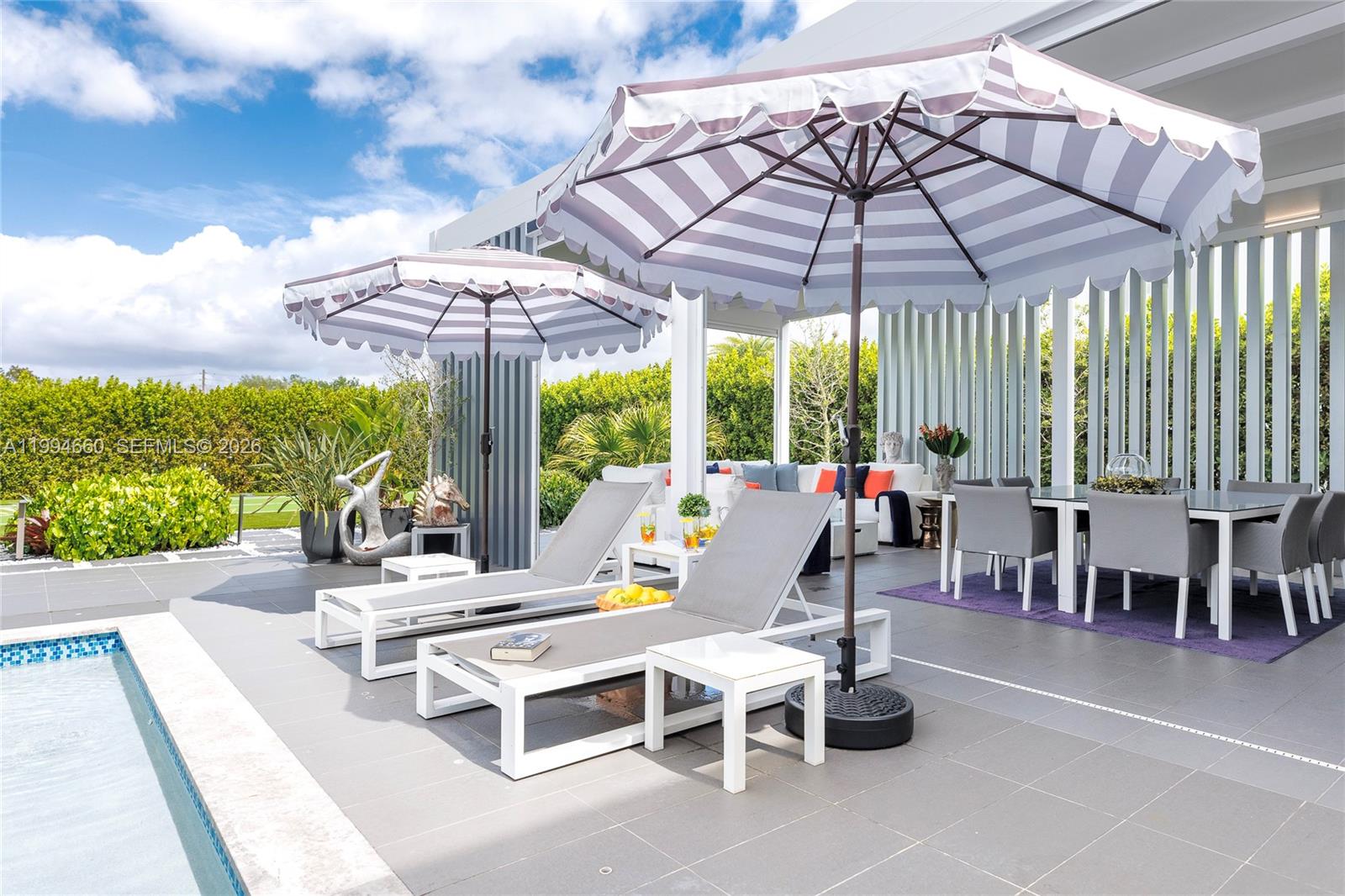16631 Sunset Way Weston, FL 33326 - Photo 47 of 59 a view of a patio with a table and chairs under an umbrella