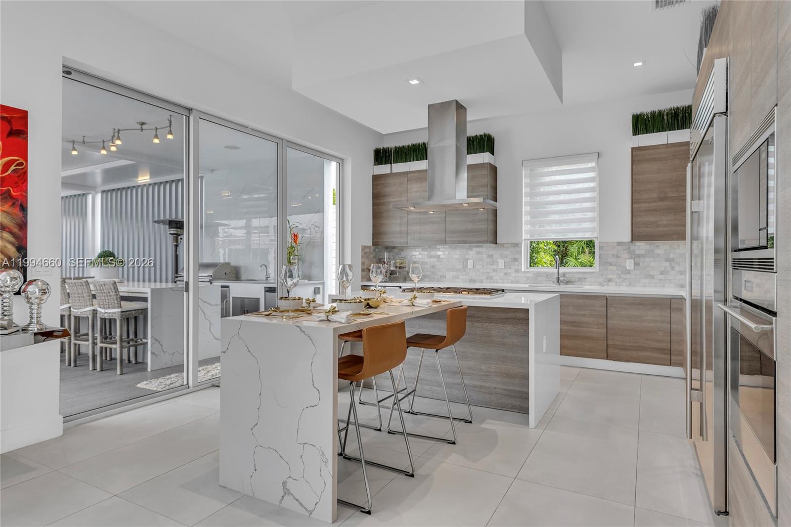 16631 Sunset Way Weston, FL 33326 - Photo 8 of 59 a kitchen with kitchen island granite countertop a counter top space appliances and a view of living room