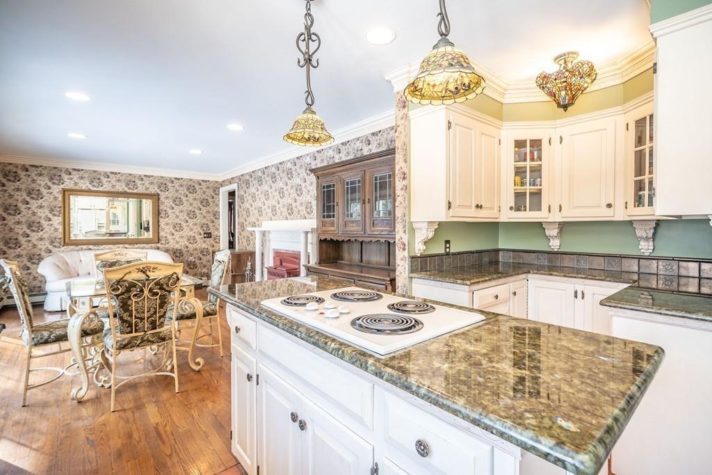 15 Fenton Road Monson, MA 01057 - Photo 26 of 41 a kitchen with kitchen island granite countertop a stove a sink a dining table and chairs with wooden floor