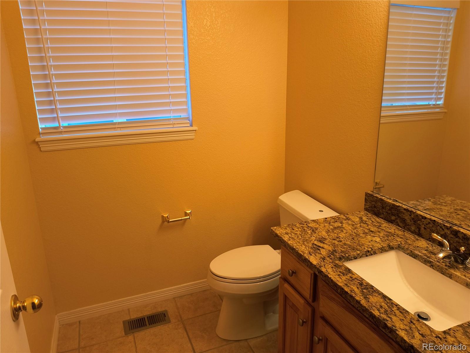 10145 Charissglen Lane Highlands Ranch, CO 80126 - Photo 12 of 39 a bathroom with a granite countertop toilet and a sink