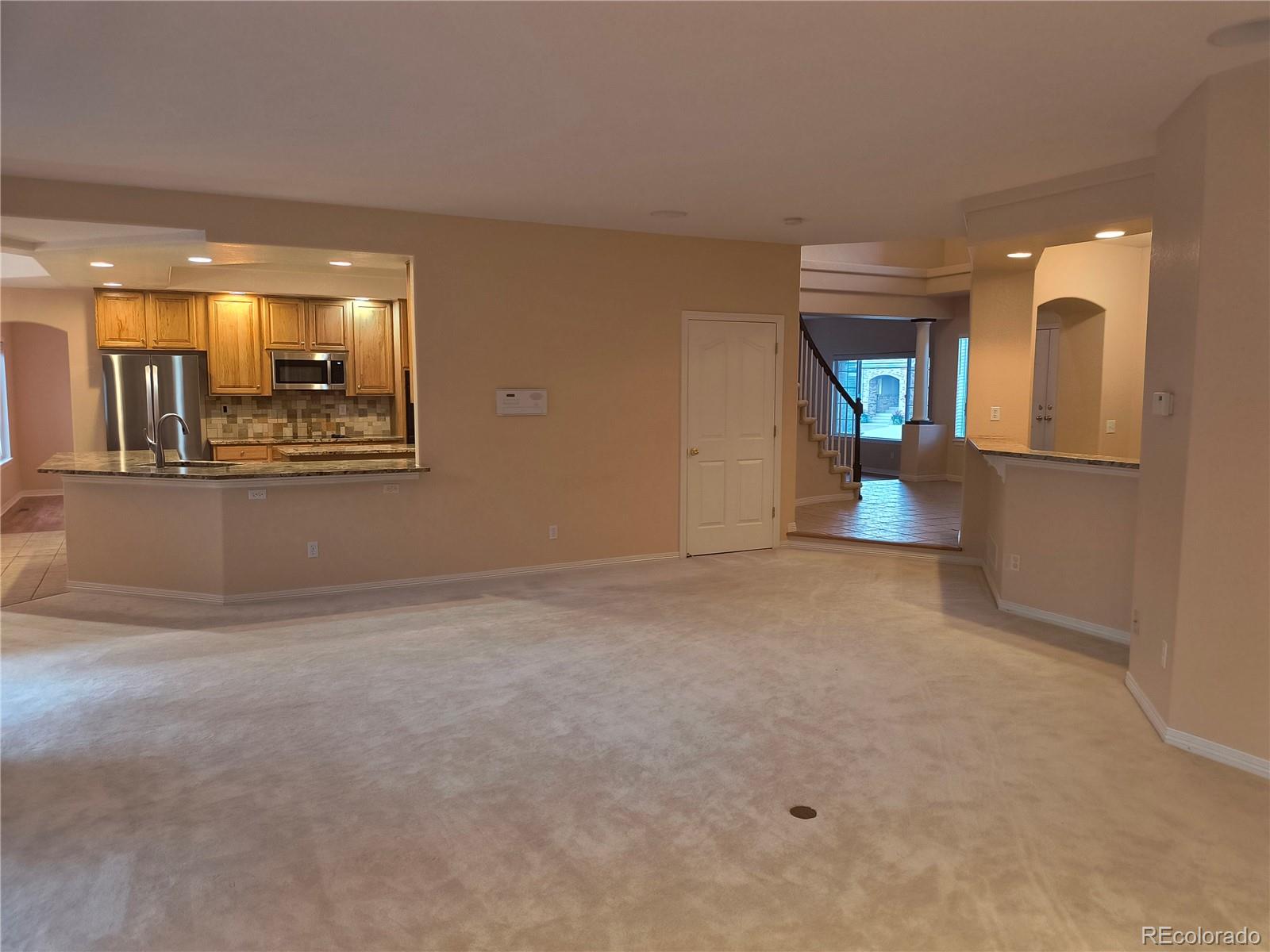 10145 Charissglen Lane Highlands Ranch, CO 80126 - Photo 5 of 39 a view of a hallway with wooden floor and a fireplace