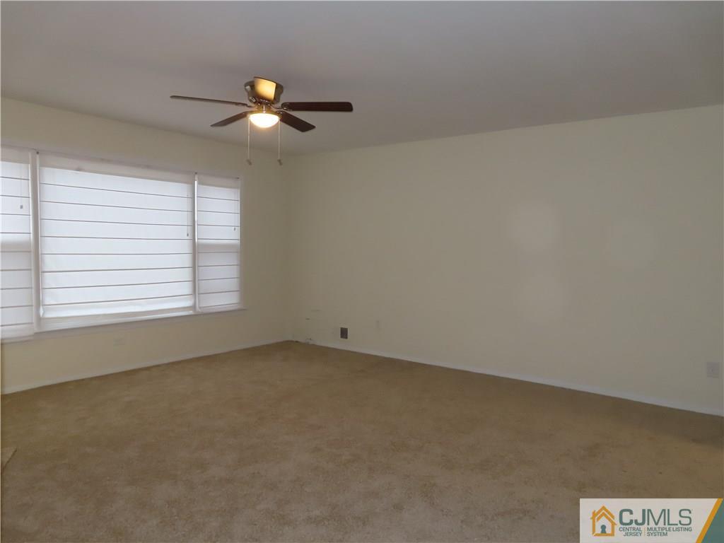 499 Harding Road Old Bridge, NJ 08879 - Photo 10 of 18 an empty room with windows and chandelier fan