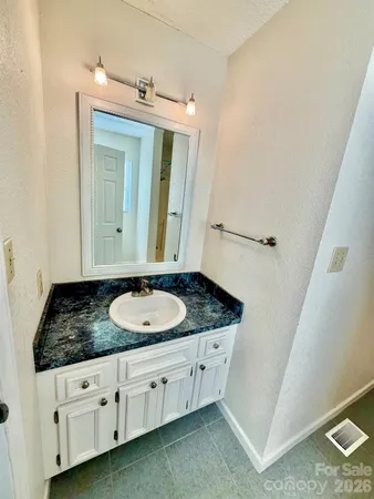 a bathroom with a granite countertop sink and a mirror