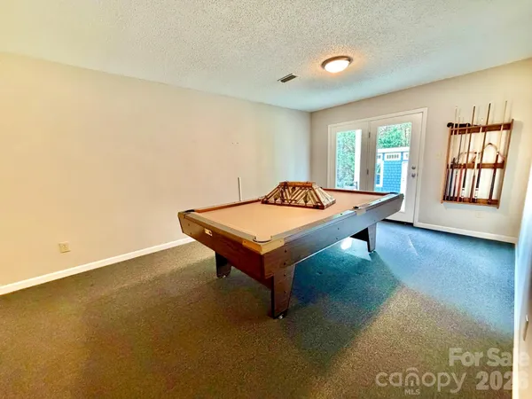 a living room with pool table and windows
