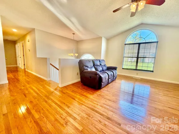 a spacious bedroom with a bed and wooden floor