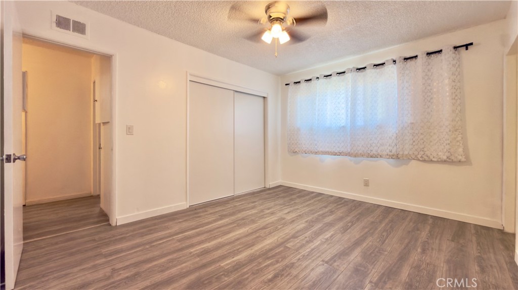 10861 Jamie Avenue Pacoima, CA 91331 - Photo 12 of 31 a view of an empty room with wooden floor and a window