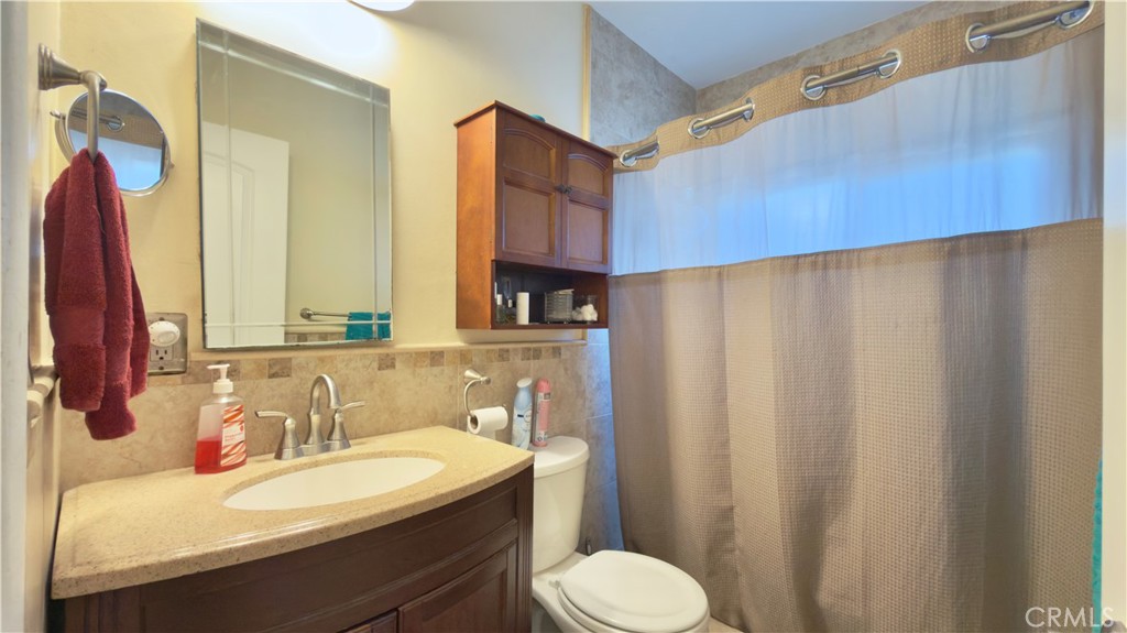 10861 Jamie Avenue Pacoima, CA 91331 - Photo 14 of 31 a bathroom with a sink a toilet and a mirror