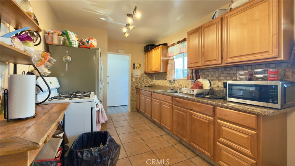10861 Jamie Avenue Pacoima, CA 91331 - Photo 20 of 31 a kitchen with stainless steel appliances granite countertop a sink dishwasher stove and refrigerator with wooden floor