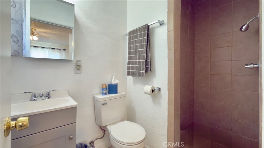 10861 Jamie Avenue Pacoima, CA 91331 - Photo 7 of 31 a bathroom with a toilet sink vanity and mirror