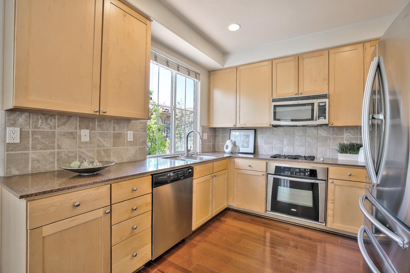 1088 Vida Larga Loop Milpitas, CA 95035 - Photo 11 of 29 a kitchen with stainless steel appliances granite countertop white cabinets granite counter tops and a window