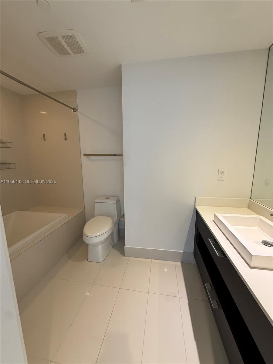 55 Southwest 9th Street, Unit 1809 Miami, FL 33130 - Photo 8 of 12 a bathroom with a granite countertop sink a toilet and bathtub