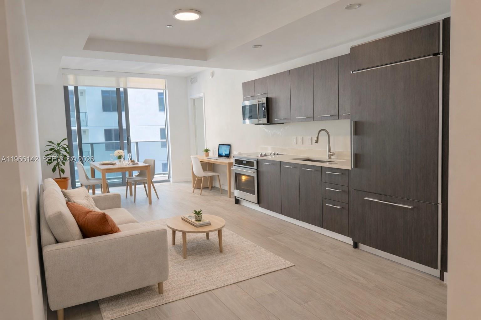 55 Southwest 9th Street, Unit 1809 Miami, FL 33130 - Photo 9 of 12 a living room with furniture a flat screen tv and kitchen view