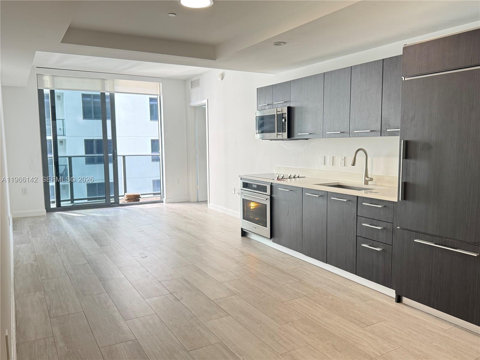 55 Southwest 9th Street, Unit 1809 Miami, FL 33130 - Photo 10 of 12 a kitchen with stainless steel appliances granite countertop a sink stove and refrigerator